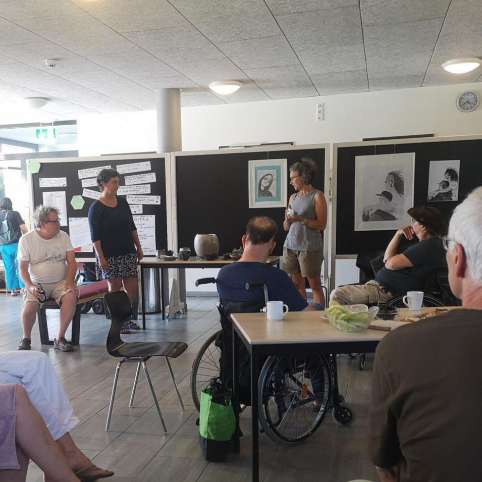 Das Bild zeigt Menschen mit und ohne Rollstuhl bei der Abschlussdiskussion im Foyer der Akademie. Das Bild zeigt Menschen mit und ohne Rollstuhl bei der Abschlussdiskussion im Foyer der Akademie