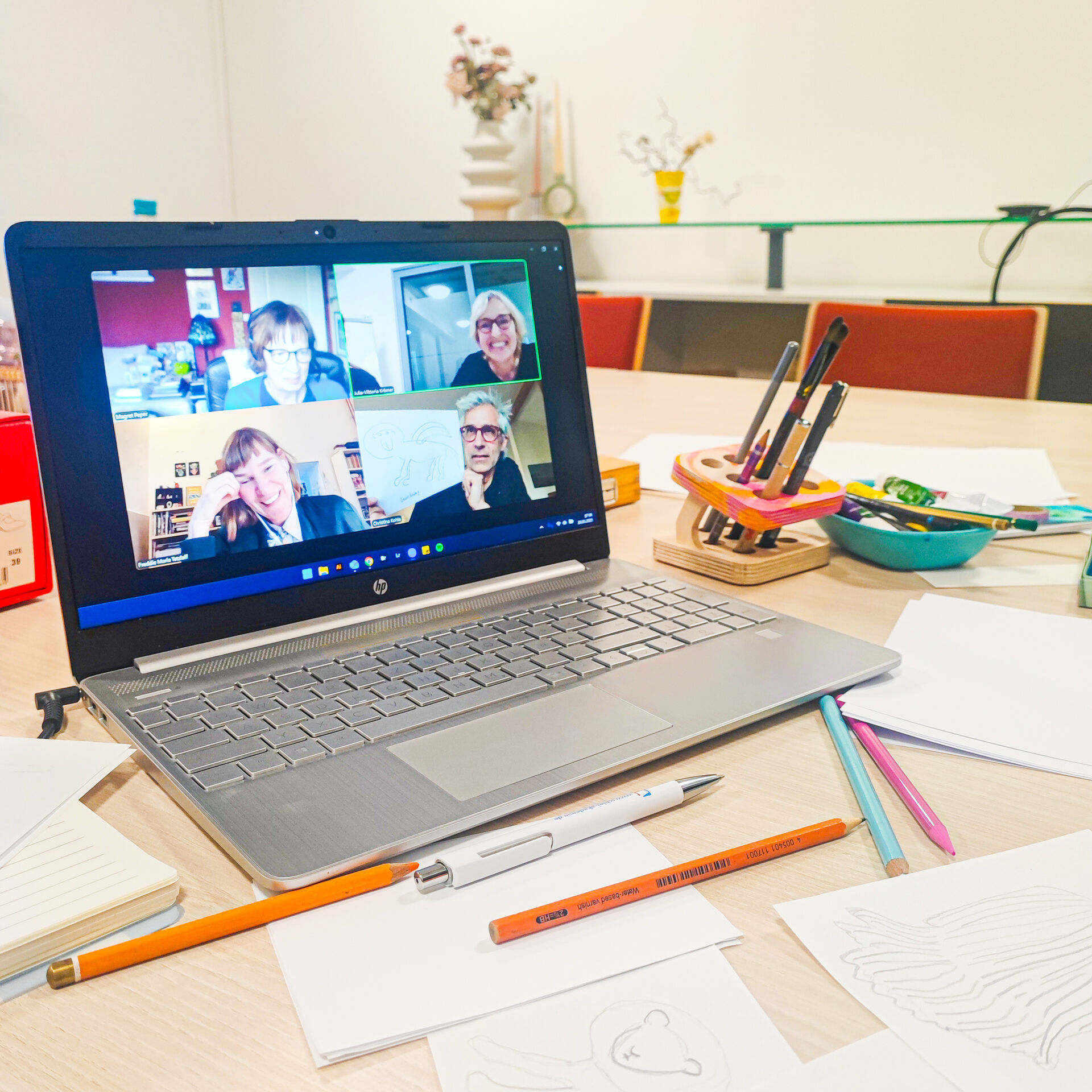 Ein Arbeitsplatz mit einem Laptop und Kunst-Materialien.