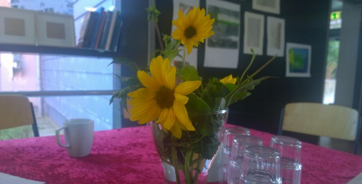 Das Foto zeigt Gläser auf einem Tisch neben einem Blumenstrauß.
