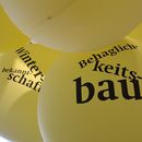 Auf gelben Ballons steht Behaglichkeitsbau und Winterbekanntschaft