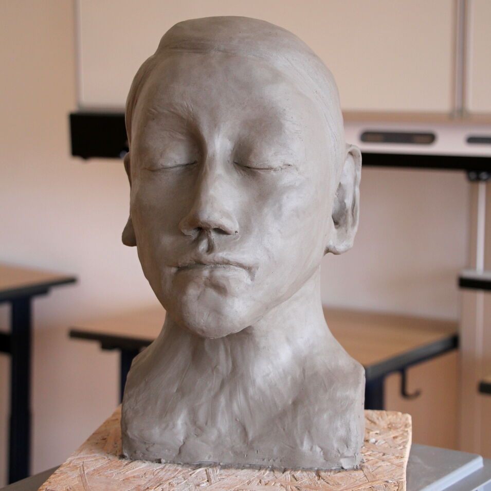 Das Bild zeigt einen modellierten Kopf mit geschlossenen Augen