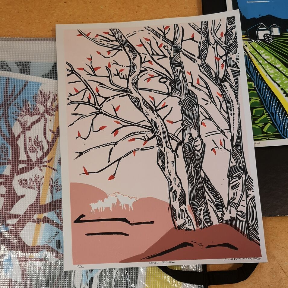 Holzschnitte und Bücher mit Bäumen liegen auf dem Tisch
