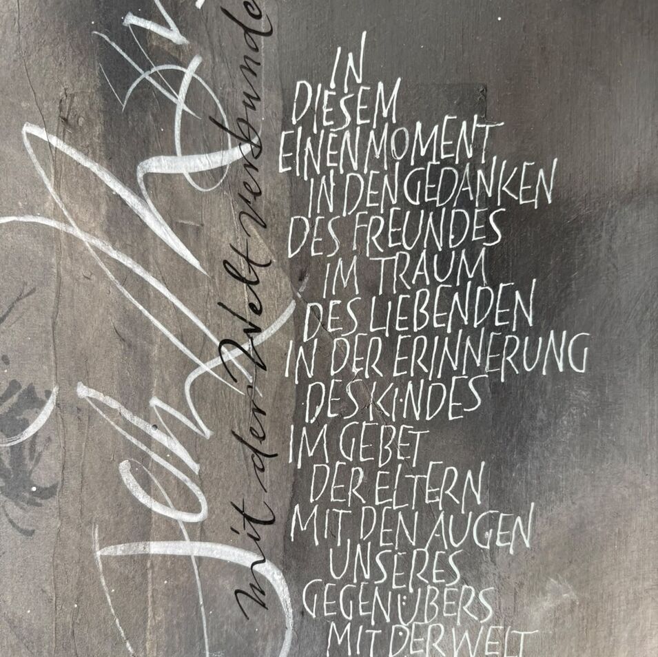 Jasna Wittmann Weiße Kalligrafie auf dunkelgrauem Hintergrund.