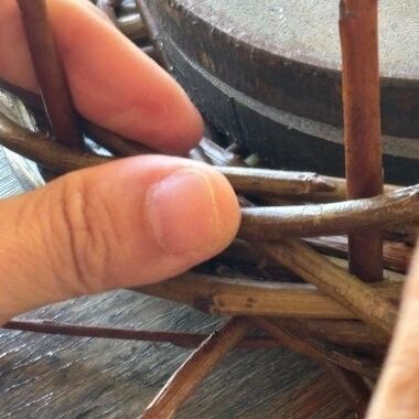 Hände beim Weidenflechten. Hier brauchst Du Kraft und Konzentration, um die Weide vorsichtig zu flechten.