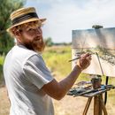 Philipp Hiller malt an der Staffelei in der Landschaft