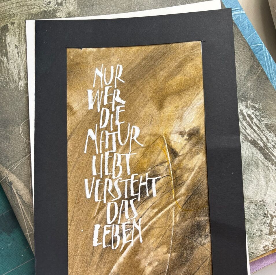 Jasna Wittmann Weiße Kalligrafie auf goldbraunem Hintergrund.
