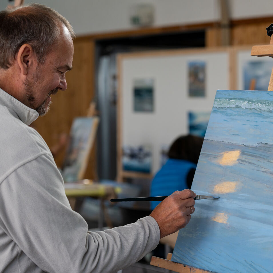 Eine Person malt in einem Atelier mit Öl.