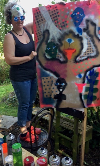 Das Bild zeigt eine Person, die eine Wand mit einem Graffiti versehen hat.