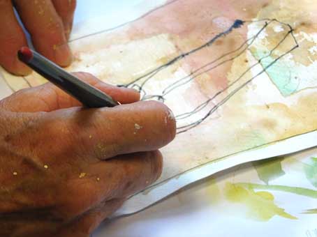 Hand, die mit Feinliner auf ein aquarelliertes Papier zeichnet